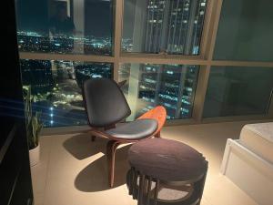 una sedia in camera con vista sulla città di Modern 2BR Apart DIFC Downtown World Trade Center a Dubai