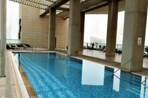una grande piscina con acqua blu in un edificio di Modern 2BR Apart DIFC Downtown World Trade Center a Dubai