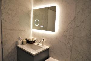 ein Bad mit einem Waschbecken und einem Spiegel in der Unterkunft Cozy place Soho London in London