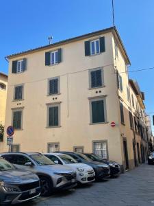 un grande edificio con macchine parcheggiate di fronte di Casa Cabernet Lucca a Lucca