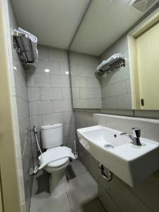 La salle de bains est pourvue de toilettes et d'un lavabo. dans l'établissement Studio Amor Apartemen Pakuwon City Mall, à Surabaya