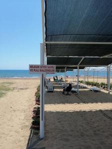 a sign on a beach with an umbrella on the beach at VİLLA KEYF in Side