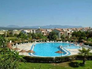 a large swimming pool with chairs and umbrellas at VİLLA KEYF in Side +12 photos