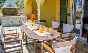 a wooden table with glasses of orange juice on a patio at Apartment Alex 3, Barbati in Barbati