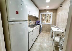 a kitchen with a white refrigerator and a sink at 1 Bedroom Apartment Second Line Beach- Parque Marbella Building in Marbella
