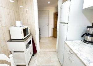 a kitchen with a white refrigerator and a microwave at 1 Bedroom Apartment Second Line Beach- Parque Marbella Building in Marbella +18 photos