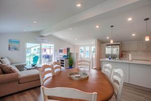 cocina y sala de estar con mesa de madera y sillas en Bayside Cove 2, en San Diego