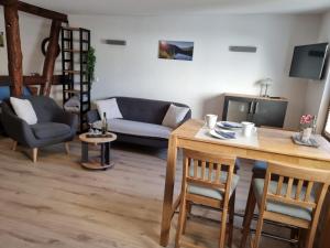 ein Wohnzimmer mit einem Tisch und einem Sofa in der Unterkunft Ferienhaus Winzerauszeit in Ellenz-Poltersdorf