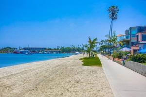 a sandy beach with palm trees and buildings at Bayside Cove 3 in San Diego