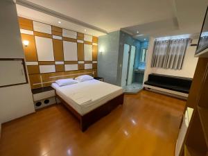 um pequeno quarto com uma cama e uma televisão em Hotel Estrela da Agua Fria em São Paulo