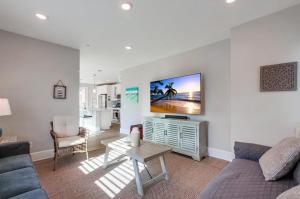 a living room with a couch and a tv on a wall at Bayside Cove 4 in San Diego
