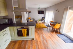 a kitchen and living room with a table and chairs at Dragonfly Lodge Ifold & Alpaca My Tipi Glamping in Billingshurst