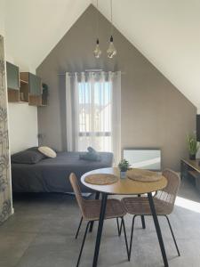 - une chambre avec un lit, une table et des chaises dans l'établissement Studio avec terrasse proche de la mer, à Lancieux