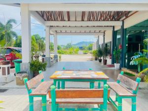Sri Embun Resort Langkawi في بانتايْ سينانج: طاولة و كرسيين امام المبنى