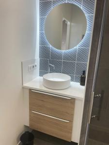 La salle de bains est pourvue d'un lavabo et d'un miroir. dans l'établissement Studio avec terrasse proche de la mer, à Lancieux