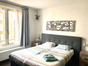 une chambre avec un lit avec une couverture et une fenêtre dans l'établissement Nicolette Apartments, à Katwijk