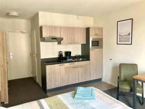 - une cuisine avec des placards en bois et une table dans une pièce dans l'établissement Nicolette Apartments, à Katwijk