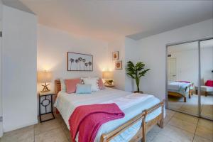 a bedroom with a large bed with a pink blanket on it at Beach Haven 1 in San Diego