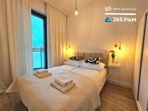 two beds in a hotel room with towels on them at Apartament Dobra Aura - 365PAM in Ustronie Morskie