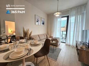 a living room with a table and a couch at Apartament Dobra Aura - 365PAM in Ustronie Morskie