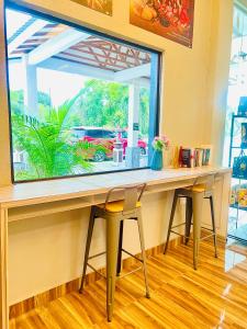 Sri Embun Resort Langkawi في بانتايْ سينانج: طاولة مع كراسي في غرفة مع نافذة كبيرة