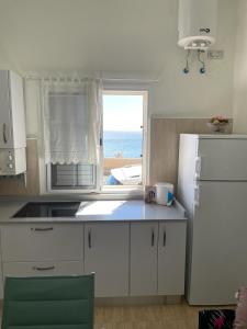 a kitchen with a white refrigerator and a window at la laja 38 in Las Palmas de Gran Canaria