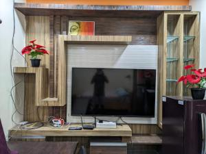 a large entertainment center with a flat screen tv at Vijayanagara Home Stay in Hampi