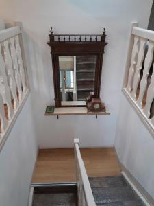 a stairway with a mirror on a shelf at Le Trois Mâts 5 in Thiers
