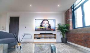 a living room with a flat screen tv on the wall at Conditioning House - Suite 2 in Bradford