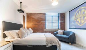 1 dormitorio con 1 cama grande y 1 silla azul en Conditioning House - Suite 2, en Bradford