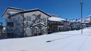una casa con graffiti sul lato della casa nella neve di Apart Hotel Bianco a El Colorado