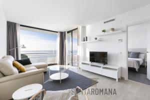 una sala de estar blanca con vistas al océano en Santa Romana Apartments & Suites en Caldes d'Estrac