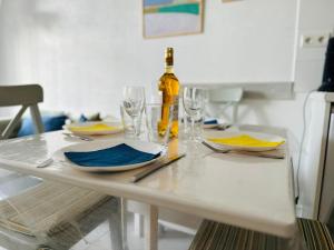 a white table with a bottle of wine and glasses at Les Obiones appartement lumineux à 150 m de la mer in Cayeux-sur-Mer +18 photos