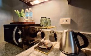 a kitchen counter with a toaster and a tea kettle at The French Apartment Pasig - Fast Wi-Fi and pool in Manila