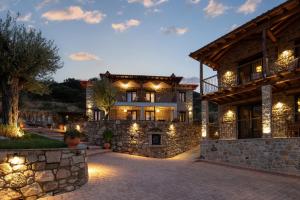 a large stone building with lights on it at Lithos Villas Apollon in Sikia