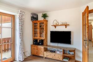 a living room with a flat screen tv on a wall at Ferienwohnung Mair - Bergblick in Halblech