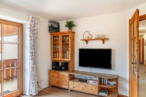 sala de estar con TV de pantalla plana en la pared en Ferienwohnung Mair - Bergblick, en Halblech