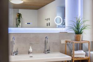 a bathroom with a sink and two faucets at Ferienwohnung Mair - Bergblick in Halblech +19 photos