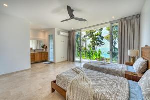 a bedroom with two beds and a balcony at Casa Heliconia in San Luis