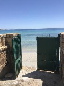 una puerta verde en la playa cerca del océano en Villa Capitana, en Capitana
