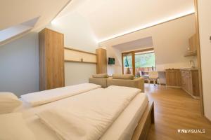 SvečinaにあるVino Valdhuber Apartmentsのベッドルーム1室(ベッド2台付)、リビングルームが備わります。