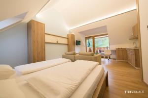 a bedroom with two beds and a living room at Vino Valdhuber Apartments in Svečina
