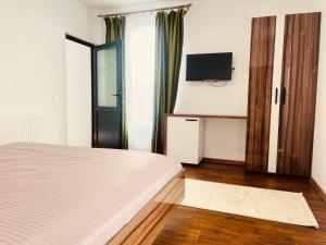 a bedroom with a bed and a flat screen tv at Green Garden in Suceava