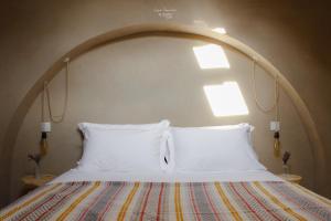 a bed with two white pillows in a room at Nomad Houses - Casa Sarilho in Beja