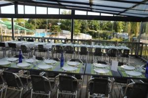 uma mesa longa com pratos brancos e cadeiras num pátio em Bungalow 3 étoiles - Parc aquatique - eeeedb em Plobannalec-Lesconil