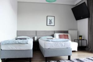 1 Schlafzimmer mit 2 Betten und einem Stuhl in der Unterkunft Labo Apartment Brylowska by EXPO XXI in Warschau
