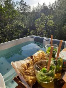 a table with some drinks and a pool of water at Caban'AO in Saint-Just-et-Vacquières