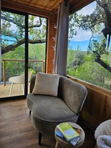 a living room with a chair and a large window at Caban'AO in Saint-Just-et-Vacquières