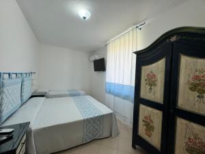 a small bedroom with a bed and a window at Garden Hotel Alghero in Fertilia