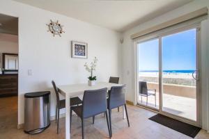 a dining room with a table and chairs and the ocean at Belmont Shores in San Diego